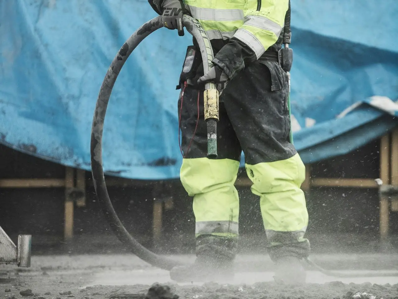 a man in a yellow uniform is using a hose